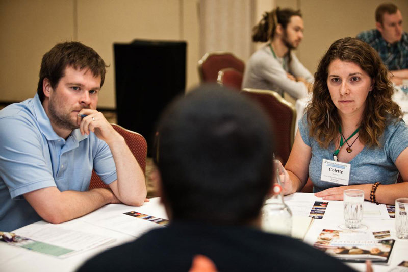 College Job fair image showing two recruiters and a student candidate.